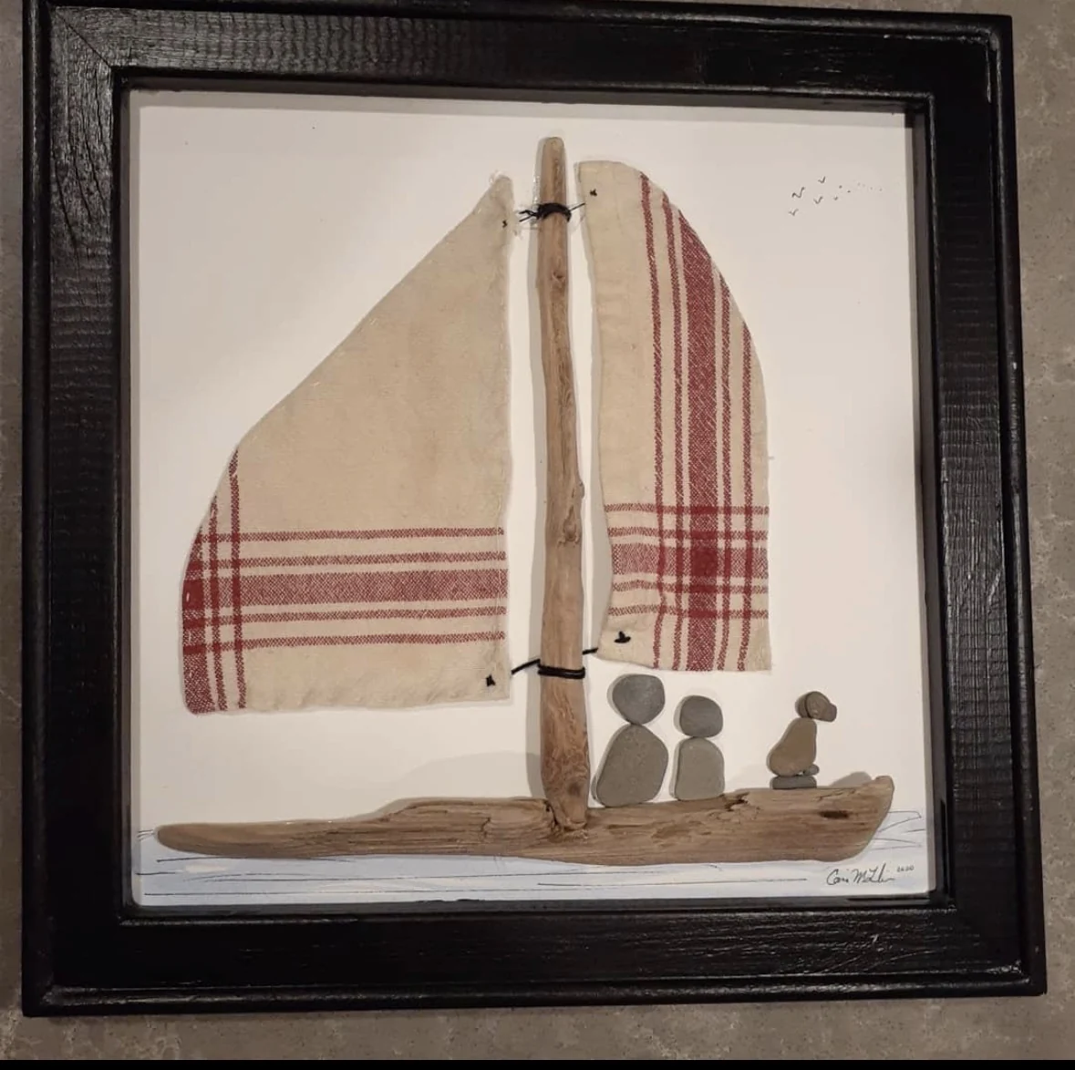 Family pebble figures aboard a sailboat made with driftwood and fabric