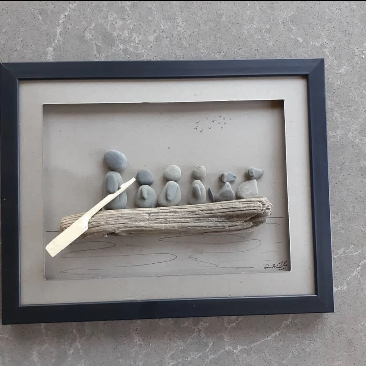 Pebble family rowing together in a driftwood boat