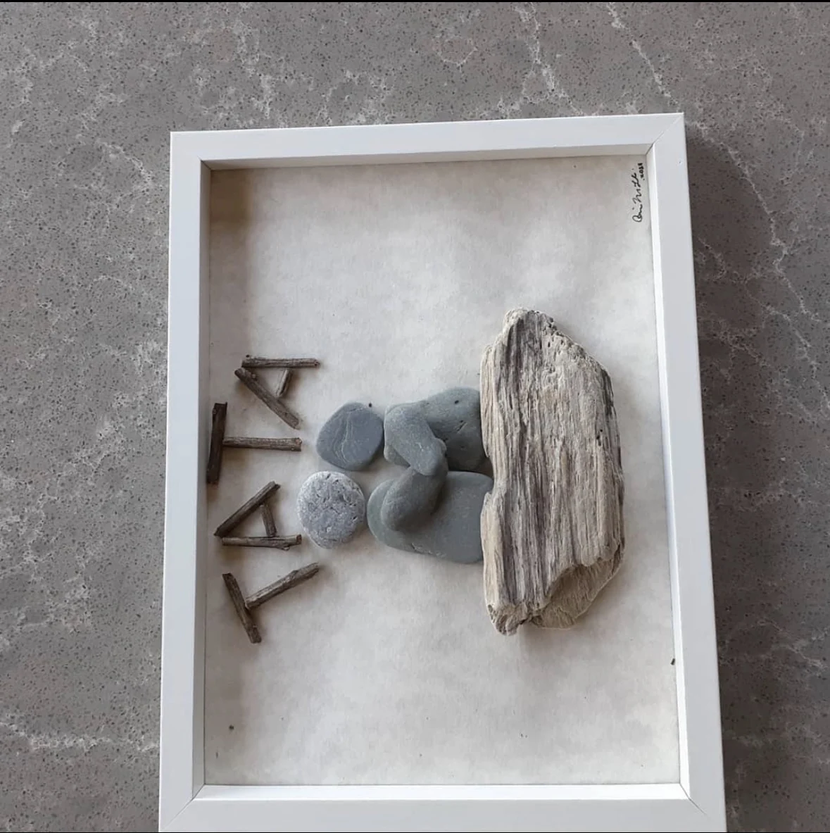 Family pebble art with driftwood and FAMILY lettering