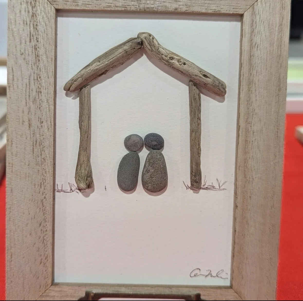 Couple pebble art beneath a simple driftwood house