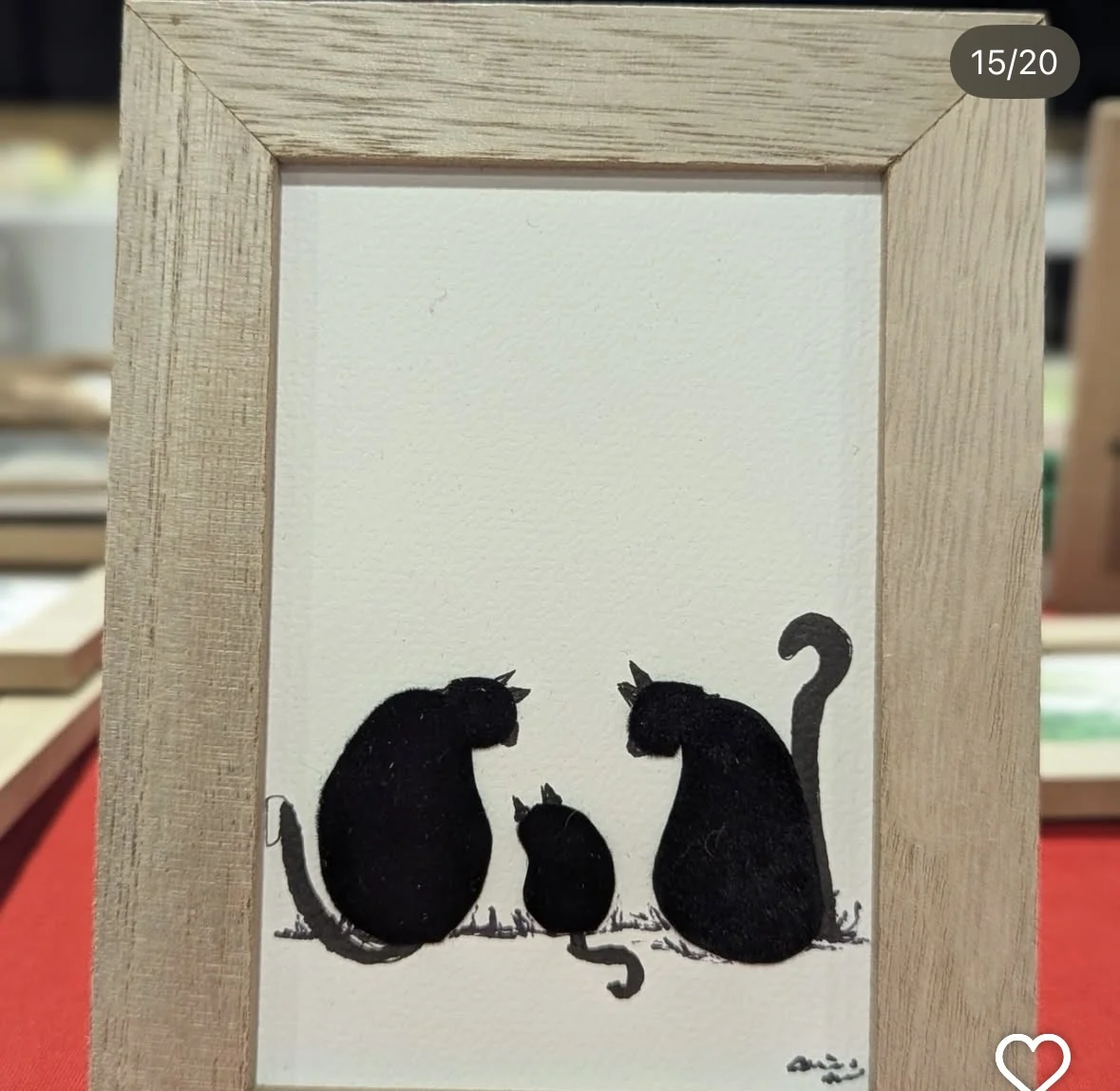 Black cat family artwork in a light wood frame