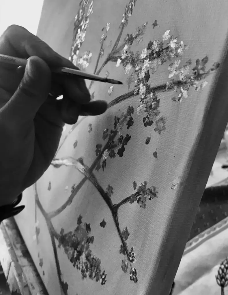 Close-up of a paintbrush adding details to a canvas